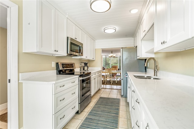 kitchen with white cabinetry, sink, light tile patterned flooring, and stainless steel appliances