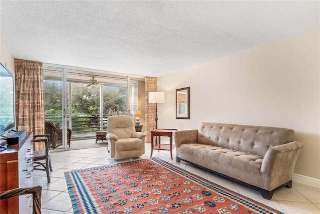 living room featuring a textured ceiling, light tile patterned floors, and ceiling fan