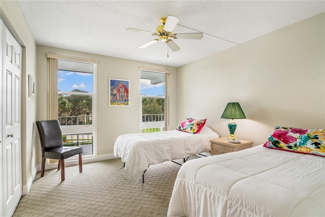 bedroom featuring ceiling fan, light carpet, a closet, and a textured ceiling