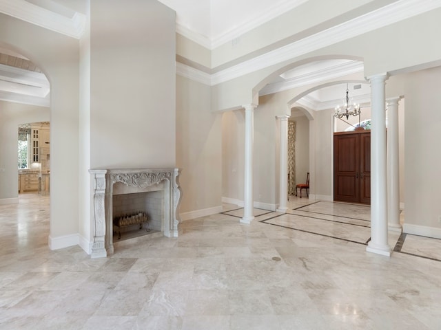 entryway with a premium fireplace, ornate columns, an inviting chandelier, and crown molding