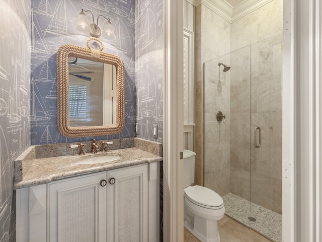 bathroom with ornamental molding, vanity, toilet, and a shower with shower door