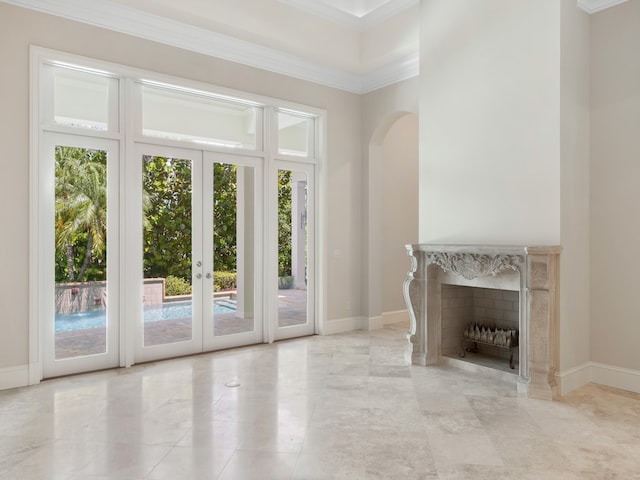 unfurnished living room featuring a fireplace, french doors, and crown molding