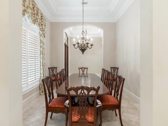 dining room featuring a raised ceiling, an inviting chandelier, and ornamental molding