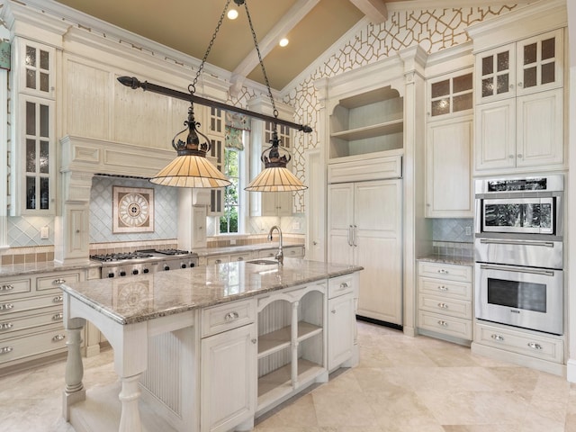 kitchen with lofted ceiling with beams, stainless steel appliances, light stone countertops, sink, and an island with sink