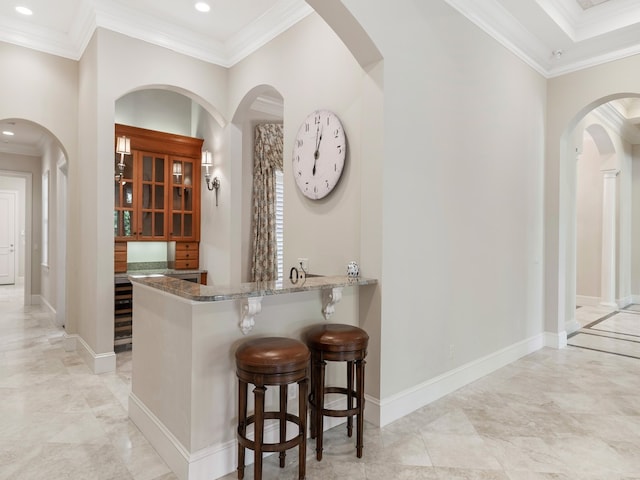 bar with light stone countertops and crown molding