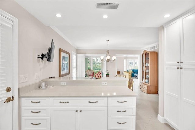 kitchen featuring decorative light fixtures, white cabinets, ornamental molding, light tile patterned floors, and an inviting chandelier