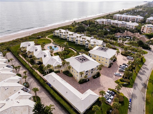 birds eye view of property featuring a water view and a beach view