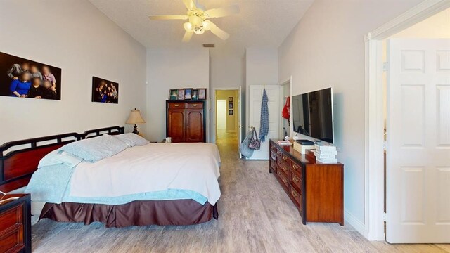 bedroom featuring high vaulted ceiling, light hardwood / wood-style floors, and ceiling fan