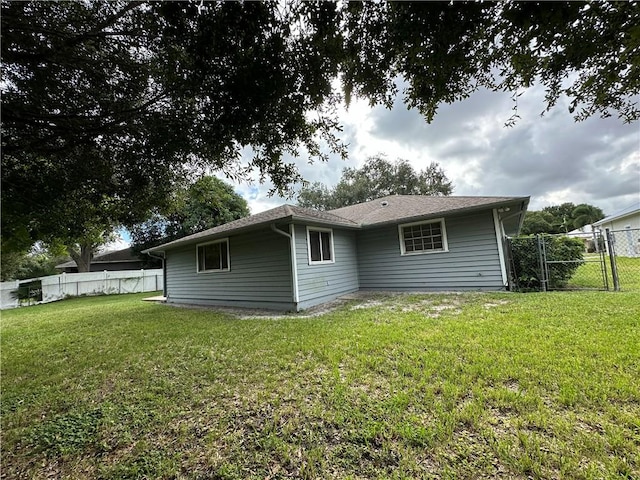 rear view of house featuring a yard