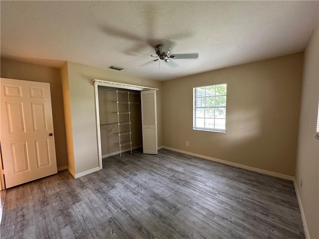 unfurnished bedroom featuring hardwood / wood-style flooring, ceiling fan, and a closet