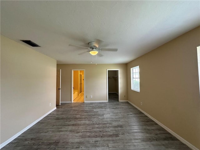 spare room with dark wood-type flooring and ceiling fan