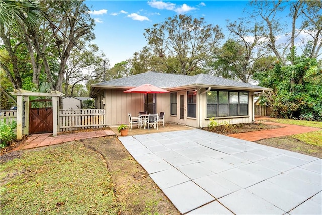 back of property with a patio area and a sunroom