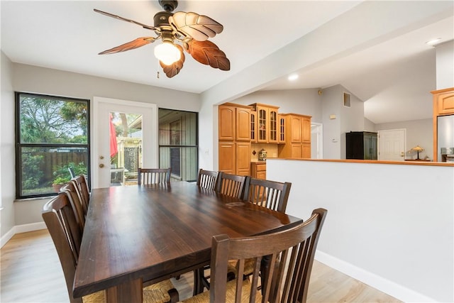 dining area featuring ceiling fan, vaulted ceiling, and light hardwood / wood-style flooring