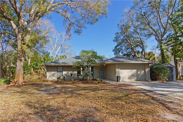 single story home featuring a storage shed, a front yard, and a garage