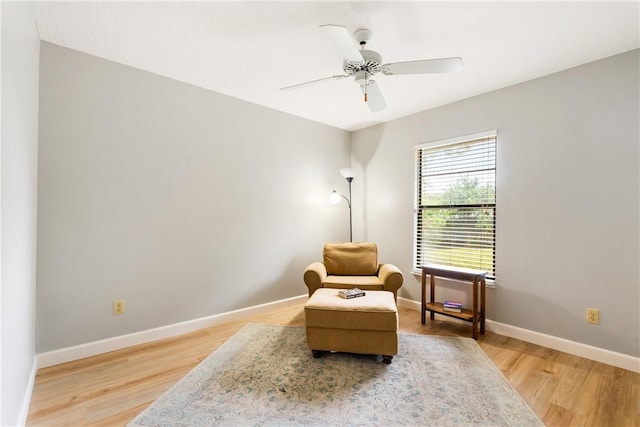 living area with hardwood / wood-style floors and ceiling fan