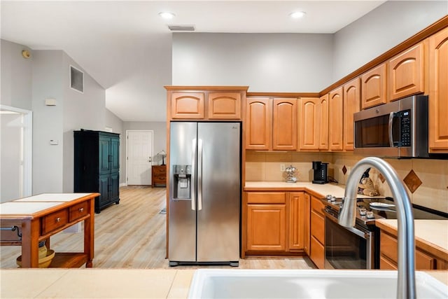 kitchen featuring stainless steel appliances and light hardwood / wood-style floors