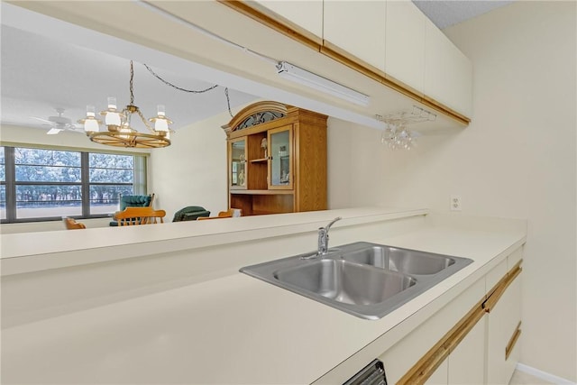 12 Plantation Dr Unit 205, Vero Beach, FL 32966 - kitchen featuring a chandelier, light countertops, white cabinetry, and pendant lighting