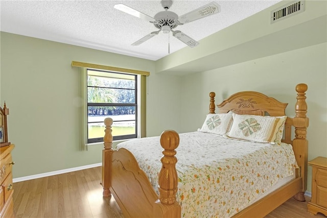 12 Plantation Dr Unit 205, Vero Beach, FL 32966 - bedroom with light wood-type flooring, a ceiling fan, and a textured ceiling