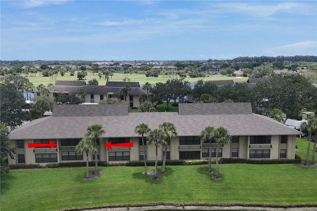 12 Plantation Dr Unit 205, Vero Beach, FL 32966 - view of front facade with a front yard, stucco siding, and roof with shingles