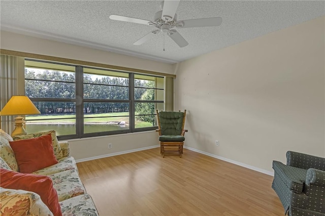 12 Plantation Dr Unit 205, Vero Beach, FL 32966 - living area featuring wood finished floors, a textured ceiling, and a ceiling fan