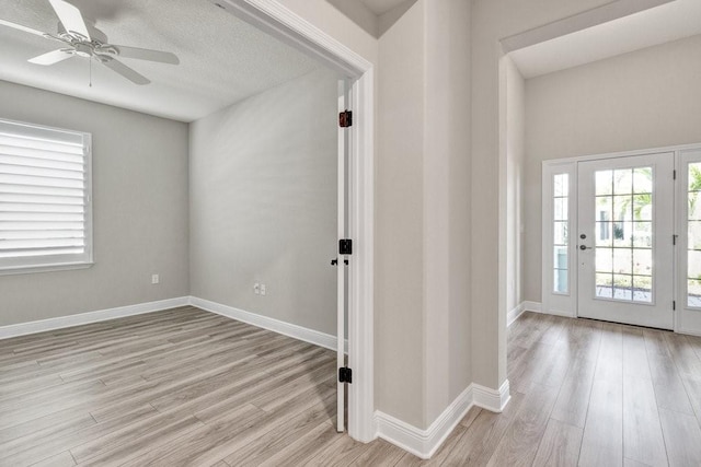 foyer with ceiling fan and light hardwood / wood-style floors