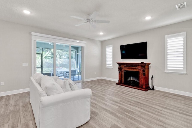 living room featuring ceiling fan and light wood-type flooring