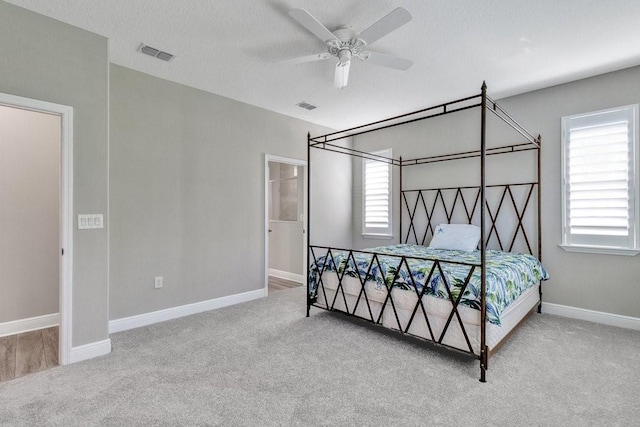 bedroom featuring multiple windows, light colored carpet, and ceiling fan