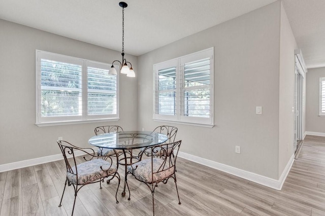 dining room with light wood-type flooring and a notable chandelier