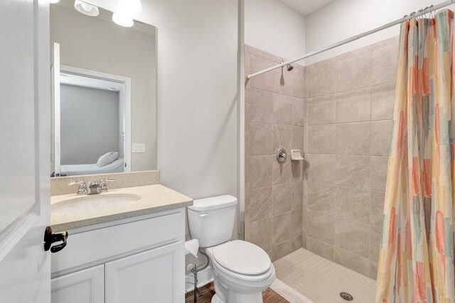 bathroom featuring toilet, vanity, and a shower with shower curtain