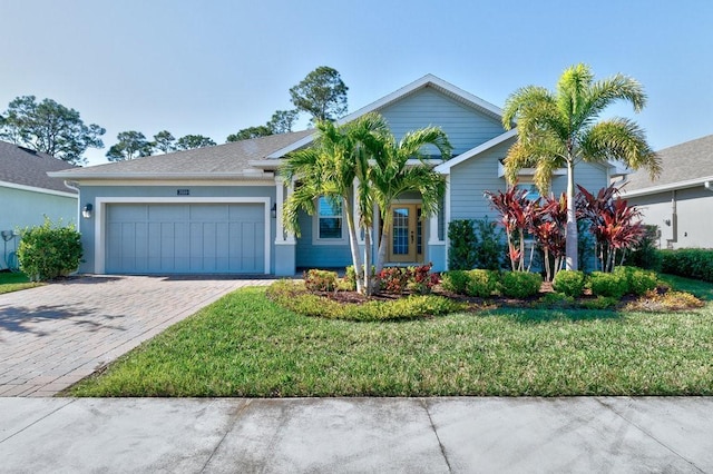 view of front of home with a front yard and a garage