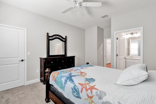 bedroom with ensuite bathroom, ceiling fan, and light colored carpet