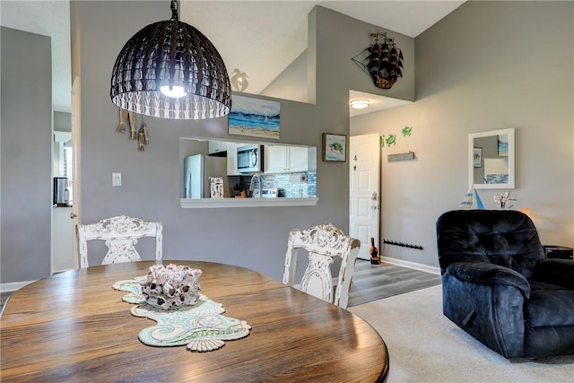 5725 Pelican Pointe Dr Unit 4, Sebastian, FL 32958 - dining space with a high ceiling, baseboards, a chandelier, and wood finished floors