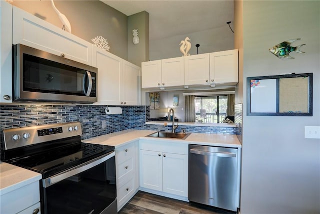 5725 Pelican Pointe Dr Unit 4, Sebastian, FL 32958 - kitchen with appliances with stainless steel finishes, tasteful backsplash, light countertops, white cabinetry, and a sink