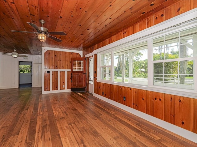 interior space featuring wooden ceiling, baseboards, a ceiling fan, and dark wood-style flooring