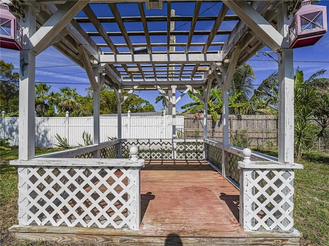 view of patio featuring fence, a wooden deck, and a pergola