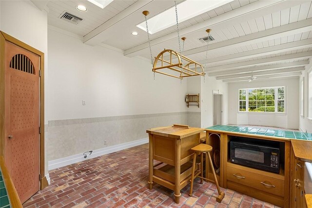 201 Sundial Ct, Vero Beach, FL 32963 - kitchen with black microwave, brick floors, tile counters, beam ceiling, and wooden ceiling