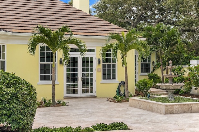 view of exterior entry with french doors and a patio