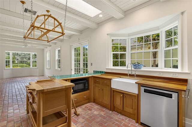 sunroom with ceiling fan, beamed ceiling, and sink