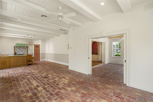 unfurnished living room featuring beamed ceiling, ceiling fan, and sink