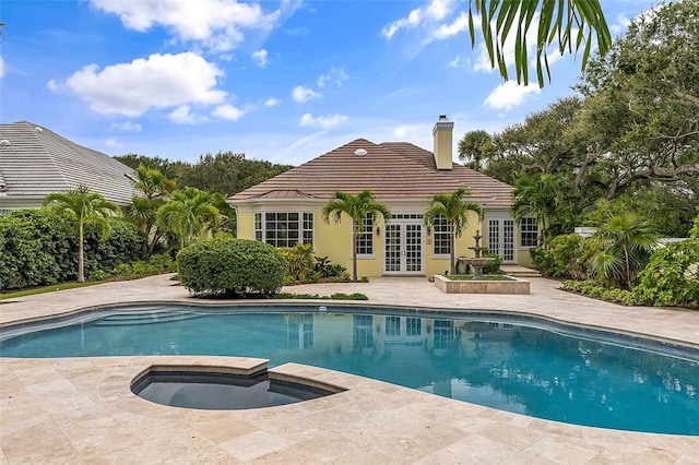 view of swimming pool with a patio, an in ground hot tub, and french doors