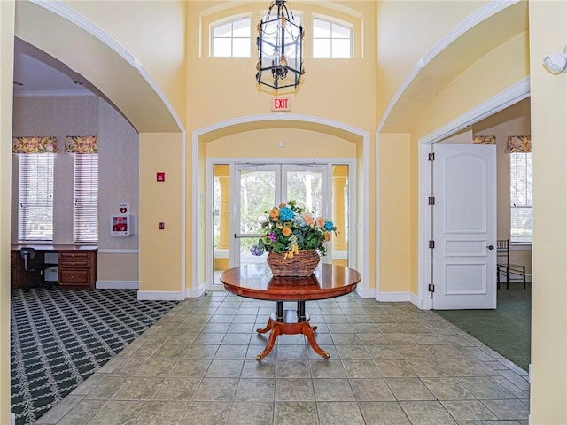 5095 Fairways Cir Unit I203, Vero Beach, FL 32967 - carpeted foyer entrance with arched walkways, a chandelier, a towering ceiling, and tile patterned flooring