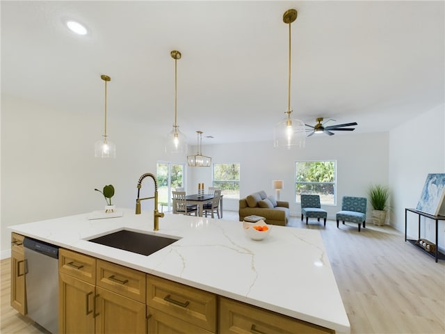 kitchen with sink, light stone counters, a center island with sink, decorative light fixtures, and stainless steel dishwasher