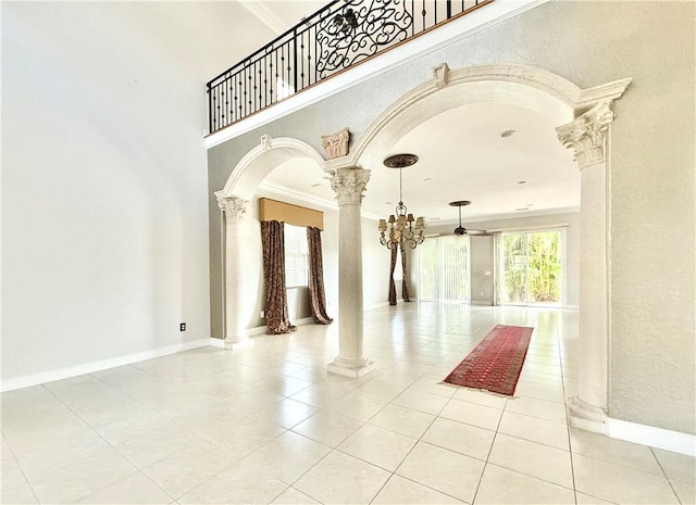 tiled living room with ceiling fan and crown molding