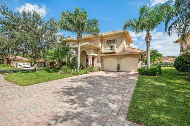 mediterranean / spanish home with a balcony, a front yard, and a garage