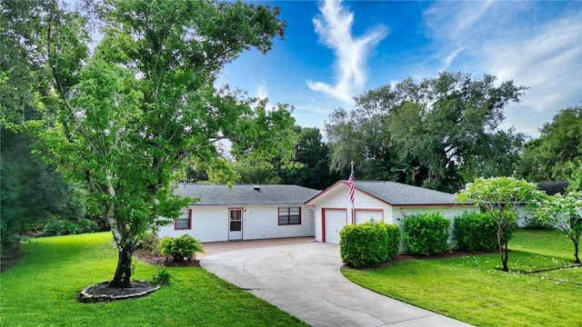 930 47th Ave SW, Vero Beach, FL 32968 - ranch-style house with concrete driveway, a garage, a front lawn, and view of scattered trees