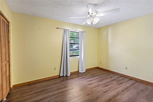 930 47th Ave SW, Vero Beach, FL 32968 - unfurnished bedroom featuring wood finished floors, a textured ceiling, baseboards, a closet, and a ceiling fan