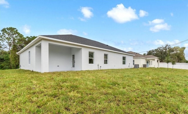 rear view of property with a yard and central AC unit