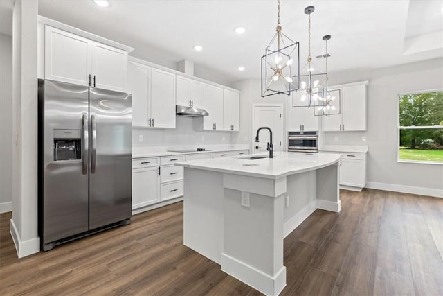 kitchen with white cabinetry, a kitchen island with sink, decorative light fixtures, and appliances with stainless steel finishes