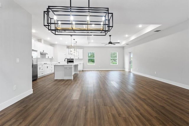 interior space with sink, dark wood-type flooring, and ceiling fan with notable chandelier