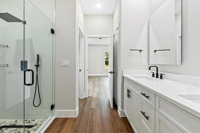 bathroom with hardwood / wood-style floors, vanity, and walk in shower